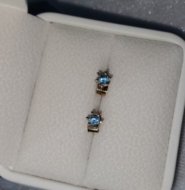 Aretes en oro de 18k con topacios azules – 1 gramo 3 USD.