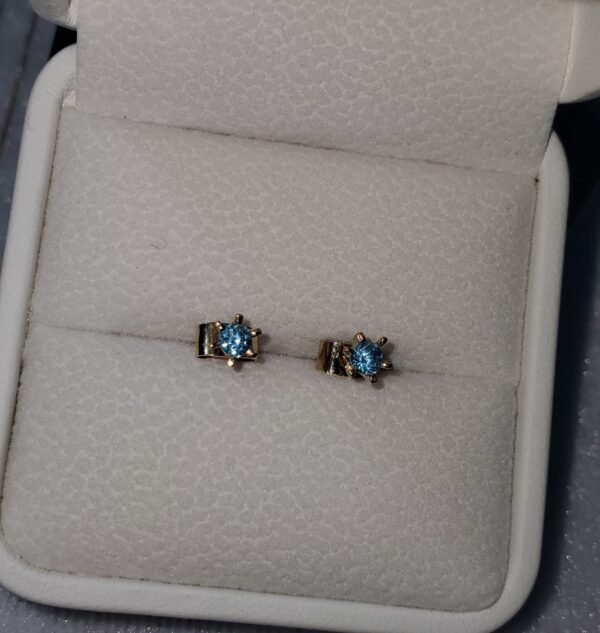Aretes en oro de 18k con topacios azules – 1 gramo 3 USD.