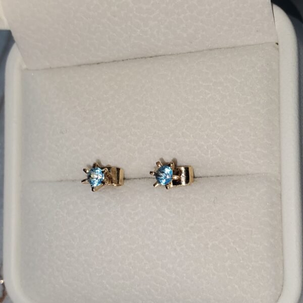 Aretes en oro de 18k con topacios azules – 1 gramo 3 USD.